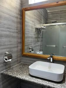ein Badezimmer mit einem weißen Waschbecken und einem Spiegel in der Unterkunft Aasna Inn in Thulusdhoo