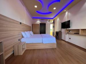 a bedroom with a bed with a blue ceiling at Aasna Inn in Thulusdhoo