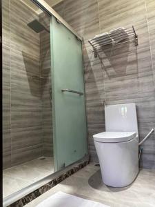 a bathroom with a toilet and a glass shower at Aasna Inn in Thulusdhoo