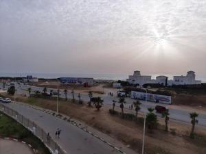 une rue avec des palmiers et des voitures sur une route dans l'établissement Tanger plage Al Houara, à Tanger