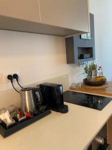 a kitchen counter with a coffee maker and a microwave at neot golf kz place in Caesarea