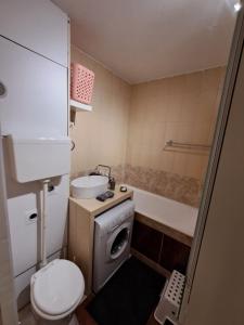 a bathroom with a toilet and a sink and a tub at Cozy Apartment in Budapest
