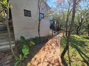 a brick sidewalk next to a house with trees at Boomhuis, Bela-Bela, Mabalingwe in Bela-Bela