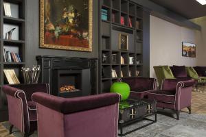 a living room with purple chairs and a fireplace at Hotel Spadai in Florence