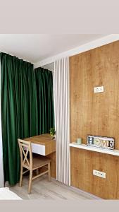 a room with a table and a green curtain at Scandinavia Apartment 1 in Piatra Neamţ