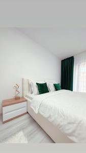 a white bedroom with a large bed and a window at Scandinavia Apartment 1 in Piatra Neamţ