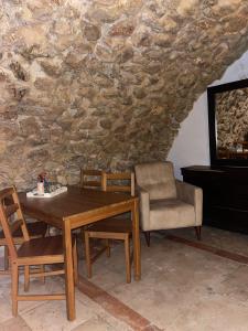 una mesa y sillas en una habitación con una pared de piedra en Jerusalem Old City room, en Jerusalén
