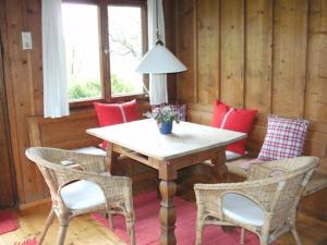 une salle à manger avec une table, des chaises et une lampe dans l'établissement Berghütterl - Ferienhaus Ingerlhof, à Tegernsee