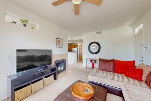 a living room with a large television and a couch at Live, Work, Play in Ahwatukee in Phoenix