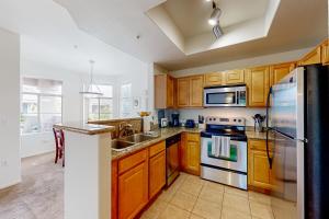 a kitchen with wooden cabinets and a stainless steel refrigerator at Live, Work, Play in Ahwatukee in Phoenix