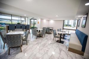 a dining room with tables and chairs and windows at La Quinta by Wyndham Dallas I-35 Walnut Hill Ln in Dallas