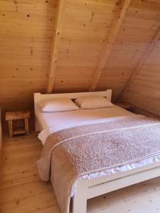 uma cama num quarto com tecto em madeira em Vrh Đevojka Villas em Žabljak