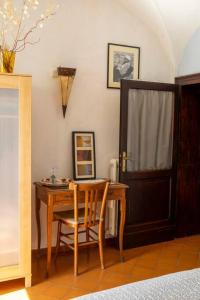 Zimmer mit einem Tisch und einem Schreibtisch mit Stuhl in der Unterkunft la casa degli Archi in Pesaro