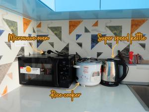 a kitchen counter with a microwave and a coffee maker at Little Cloud Home Vũng Tàu - CSJ Tower in Vung Tau