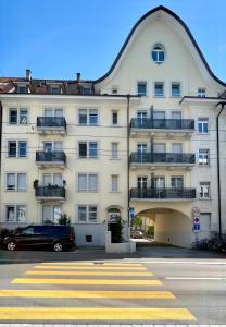 un grand bâtiment blanc avec une promenade de plain-pied devant. dans l'établissement Seefeld Residenz, à Zurich
