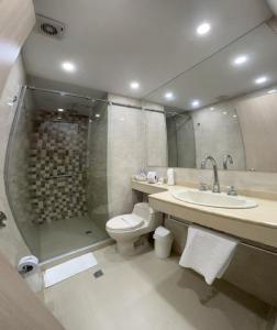 a bathroom with a toilet and a sink and a shower at Hotel Juan Maria in Tuluá