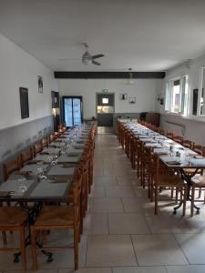 a large room with long tables and wooden chairs at Sas O REGAL in Villeneuve-sur-Lot