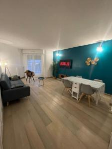 Appartement centre ville tout confort et spacieux في سيرُجي: غرفة معيشة مع أريكة وطاولة