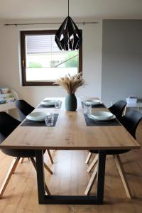una mesa de comedor de madera con sillas y un jarrón en Ferienwohnung Hans im Glück en Olbernhau