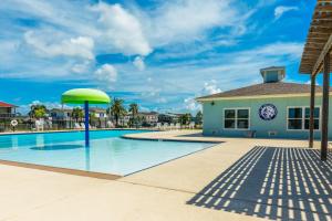 a swimming pool with a clock on a building at Paradise Perch in Galveston