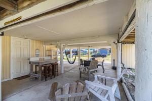 een veranda met houten banken en een tafel en stoelen bij Paradise Perch in Galveston