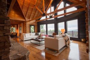a living room with two couches and a table at The Ridge: A Modern Cabin in Bostic