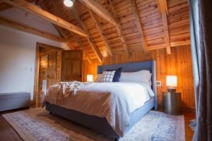 a bedroom with a bed in a room with wooden walls at The Ridge: A Modern Cabin in Bostic