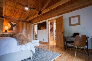a bedroom with a bed and a desk in a room at The Ridge: A Modern Cabin in Bostic