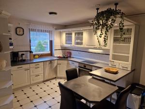 a kitchen with white cabinets and a table with chairs at Ferienwohnung Hans im Glück in Olbernhau