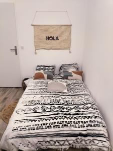 ein Bett mit einem heiligen Schild darüber in einem Schlafzimmer in der Unterkunft Grande Chambre Neuve Parking prive Cergy RER in Cergy