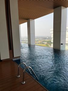 a swimming pool with a chair in a building at Parisian style apartment at The Smith Alam Sutera in Tangerang