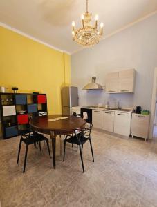 uma cozinha com mesa e cadeiras num quarto em CAROLINA'S APARTMENT em Caserta