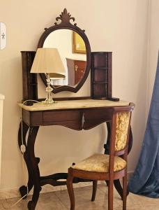 um toucador com um espelho e uma cadeira em CAROLINA'S APARTMENT em Caserta