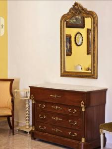 uma cómoda com um espelho em cima em CAROLINA'S APARTMENT em Caserta