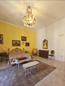 um quarto grande com uma cama e um lustre em CAROLINA'S APARTMENT em Caserta