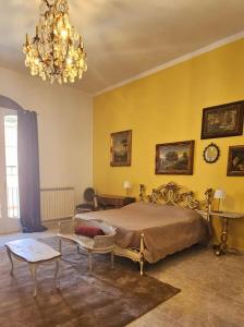 um quarto com uma cama e um lustre em CAROLINA'S APARTMENT em Caserta