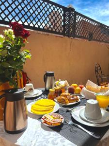 a breakfast table with food and drinks on it at Riad Les Miroirs in Marrakech