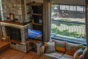 a living room with a couch and a fireplace at Lake Plastira Lodge in Kalyvia