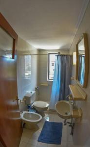 a bathroom with two sinks and a toilet and a mirror at Lake Plastira Lodge in Kalyvia