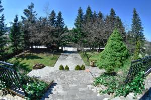 un jardín con un camino de piedra y dos árboles en Lake Plastira Lodge, en Kalyvia