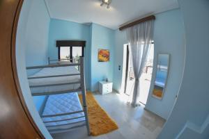 1 dormitorio con 1 litera en una pared azul en Lake Plastira Lodge, en Kalyvia