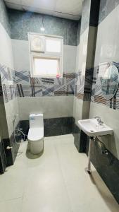 a bathroom with a toilet and a sink at Atulyam Stays Sushant Golf City in Lucknow