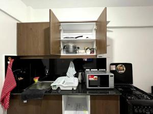 a kitchen counter with a sink and a microwave at Sunset Studio in Kiambu