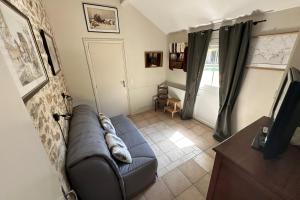 a living room with a blue couch and a tv at Rare pearl with garden near the sea in La Baule +26 photos