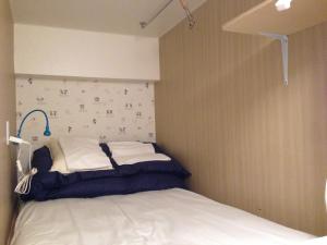 北九州市にある福岡 ゲストハウス リトル アジア 小倉の壁のある部屋の小さなベッド1台分です。