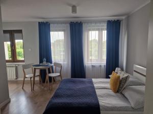 a bedroom with a bed and a table with chairs at Pokoje Gościnne Cztery Wiatry in Frombork