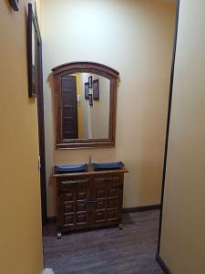 a bathroom with a mirror and a wooden dresser at León Antiguo Palomera in León