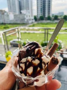 a person holding a chocolate dipped ice cream dessert at Atulyam Stays Sushant Golf City in Lucknow