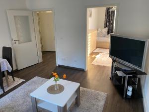 a living room with a tv and a table with flowers at Ferienwohnung Pension Sofia 2 in Meißen