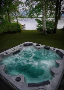 Stratford的住宿－Chalet Le Shack O2，庭院内带绿色水的按摩浴缸
